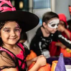 Dziewczynka w stroju czarownicy z makijażem na Halloween. Pomysł na to, jak zrobić strój czarownicy dla dziewczynki.