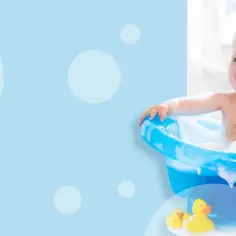 Radosne dziecko w pianie, kiedy dziecku rosną włosy, pluska się w wannie z gumowymi kaczątkami.