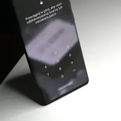 Ekran blokady telefonu z klawiaturą numeryczną i instrukcją "Przeciągnij w górę, aby użyć odblokowywania twarzą lub odciskiem palca". Może to być pomocne, gdy zastanawiasz się, jak usunąć blokadę rodzicielską Google.