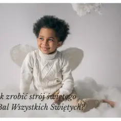 Uroczy chłopiec w białym swetrze i anielskich skrzydłach. Inspiracja, jak przebrac dziecko za świętego na bal.
