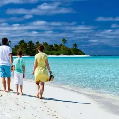 Rodzina spaceruje po rajskiej plaży. Idealne miejsce, gdzie jechać z rocznym dzieckiem na wakacje marzeń.