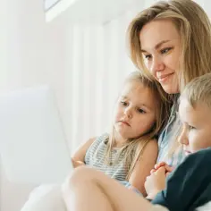 Mama z dwójką dzieci ogląda coś na laptopie. Czy dziecko może zdecydować z którym rodzicem chce mieszkać?