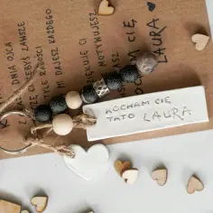Brelok z napisem "Kocham Cię Tato Laura" i serduszkami. Symbolizuje miłość i wdzięczność, co oznaczają klucze na roczek dla taty.