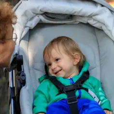 Babcia rozmawia z wnukiem w wózku. Ciekawe, ile bierze niania za godzinę, żeby zapewnić taką troskę.