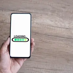 Dłoń trzyma smartfon z ekranem ładowania. Czas na odinstalowanie aplikacji kontrola rodzicielska.