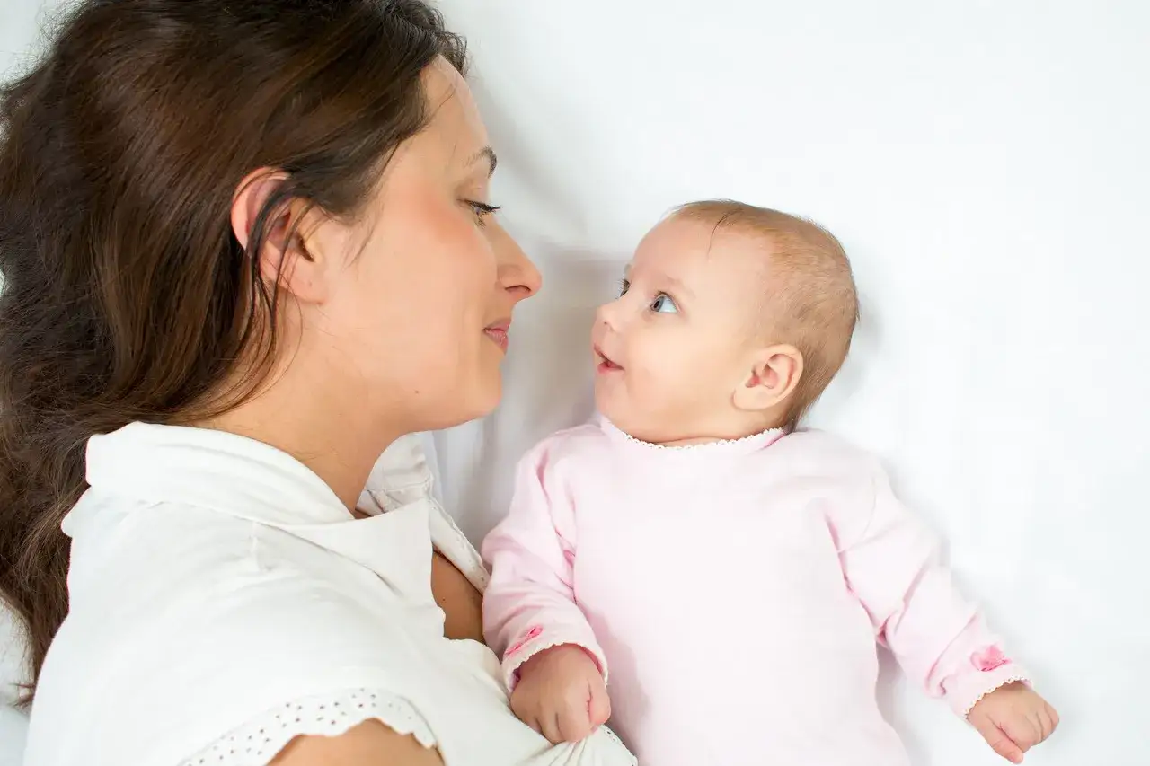 Mama patrzy na swoje tygodniowe dziecko, które z zaciekawieniem obserwuje świat.