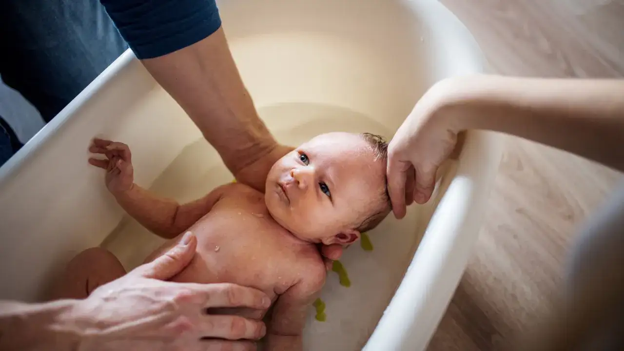 Rodzice delikatnie kąpią noworodka w wanience. Czy kąpać niemowlę z gorączką? To pytanie nurtuje wielu rodziców.