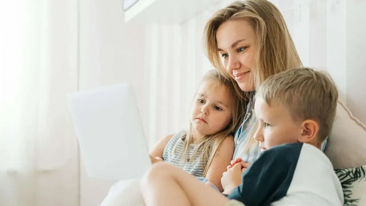 Matka z dwójką dzieci ogląda coś na laptopie. Czy dziecko może zdecydować z którym rodzicem chce mieszkać?