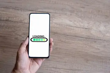 Dłoń trzyma smartfon z ekranem ładowania. Czas na odinstalowanie aplikacji kontrola rodzicielska.